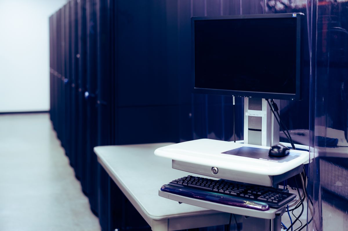 Workstation beside illuminated server racks
