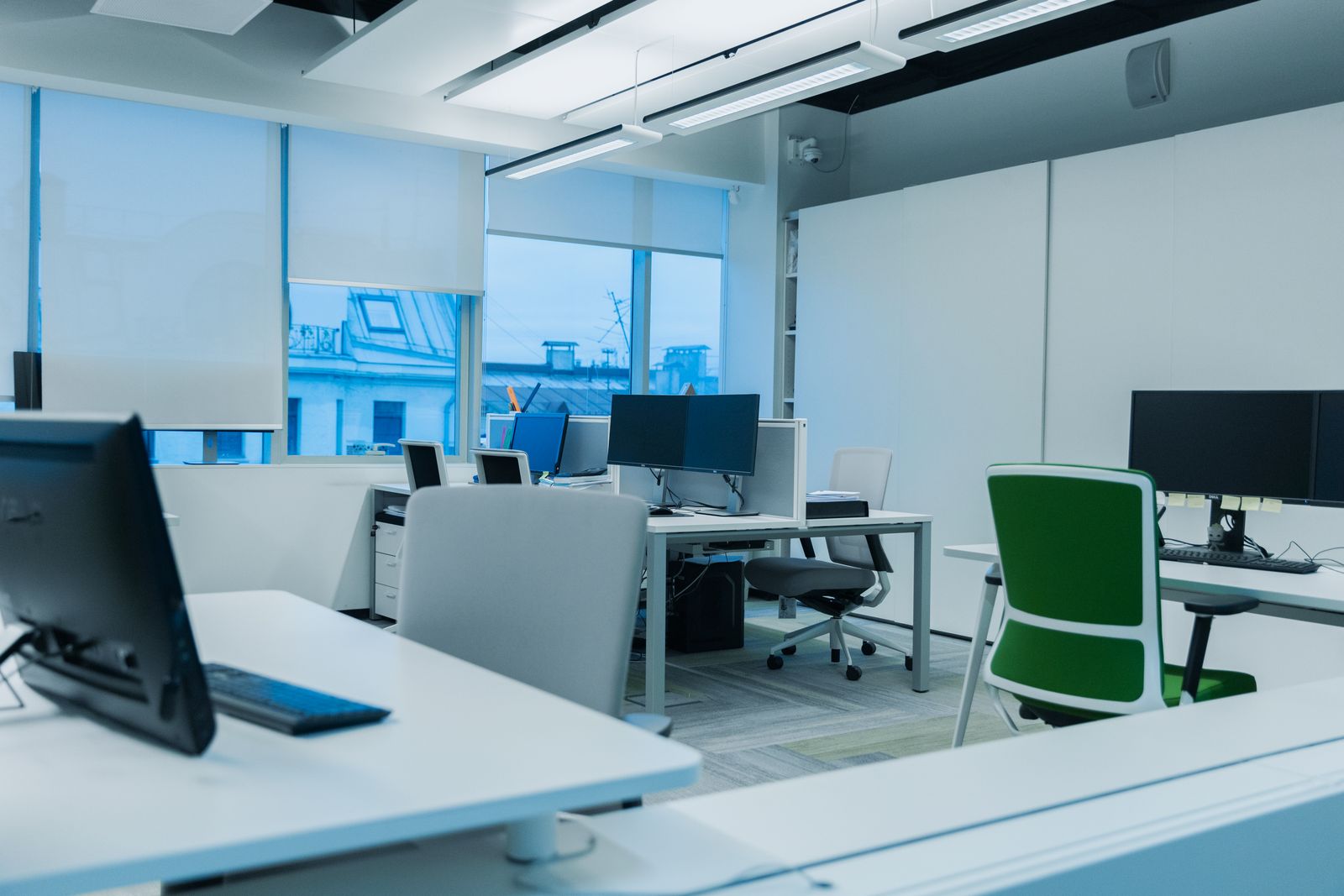 Bright modern IT workspace with analysts at multiple monitors